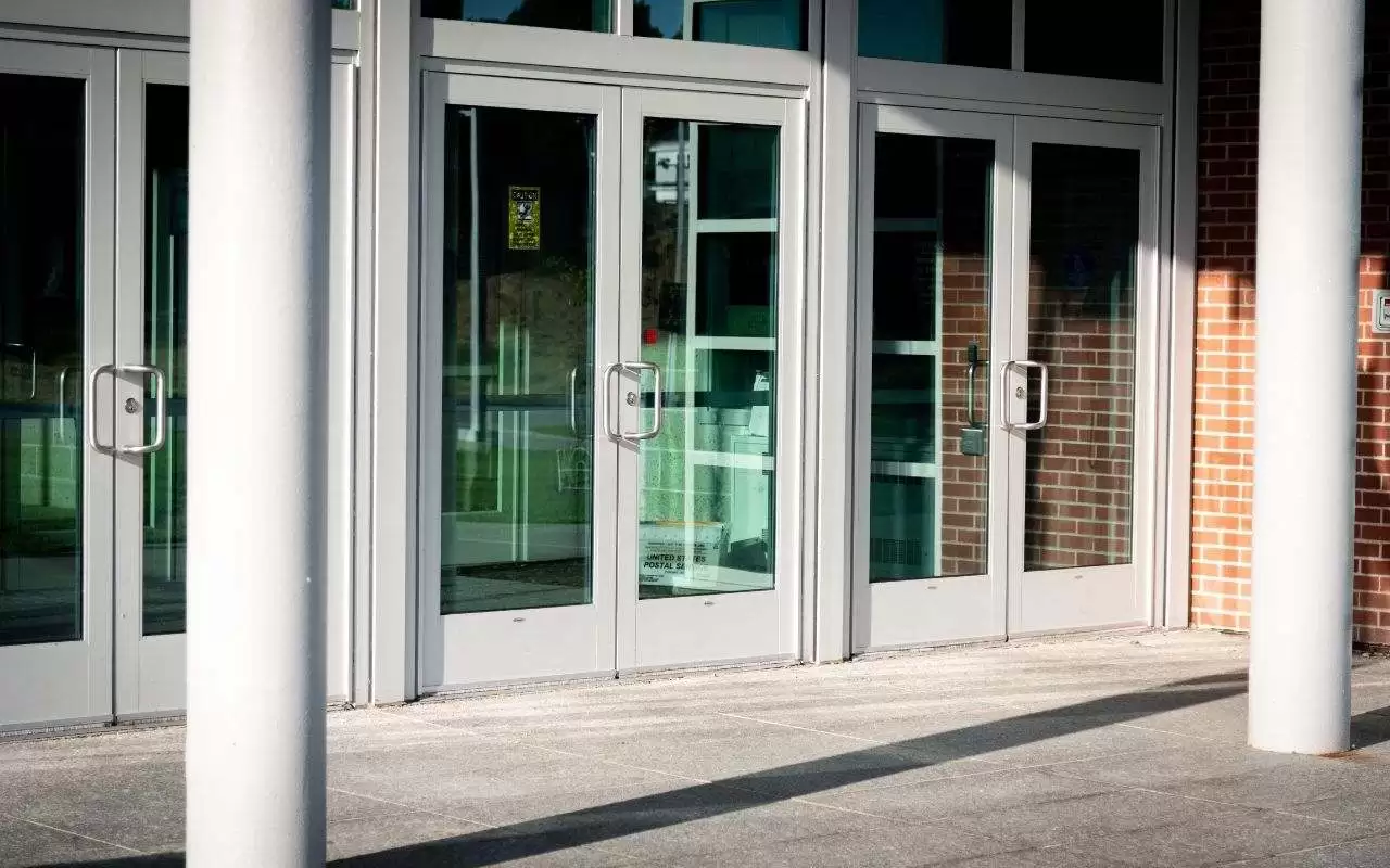 A sticking commercial door with signs of swelling and wear.